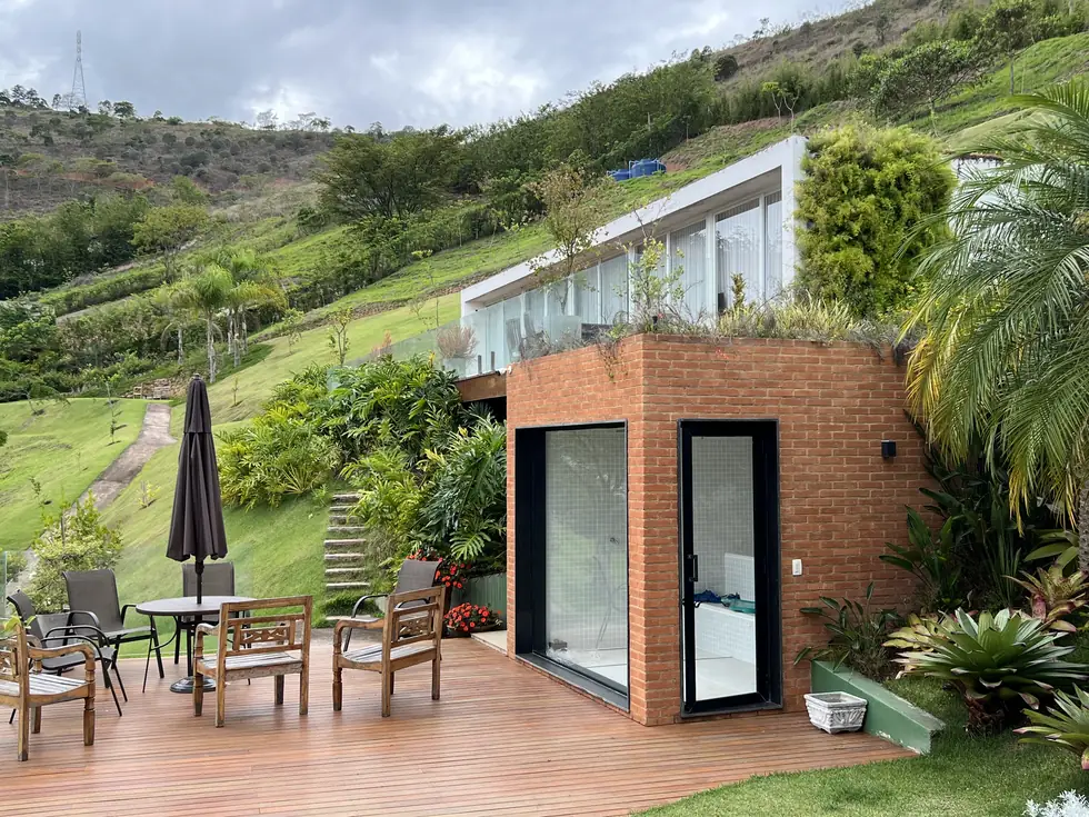 Varanda e jardim em residência de tijolo aparente — NS Engenharia