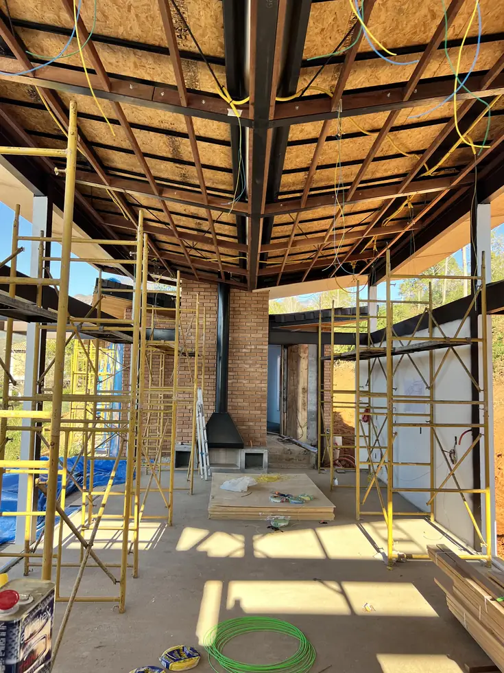 Interior em obra com andaimes e lareira — NS Engenharia