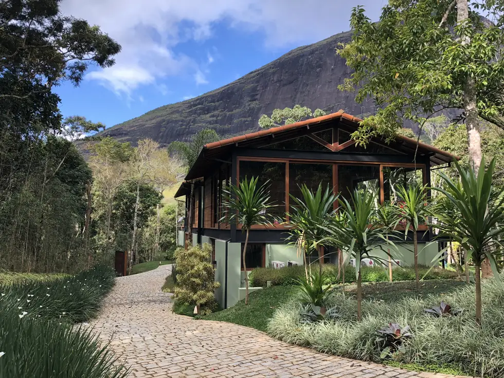 Casa envidraçada ao pé da pedra, com acesso em paralelepípedos — NS Engenharia